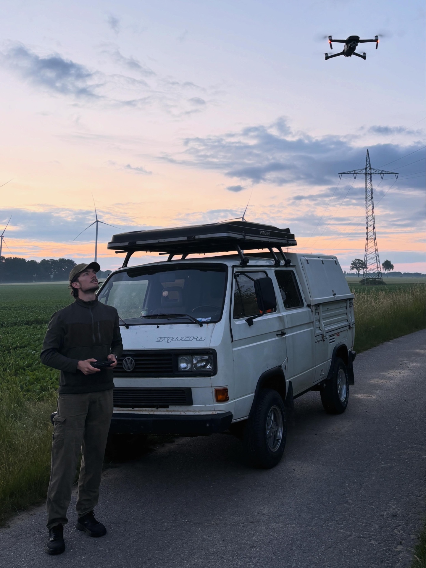 Hans Wächtler, Gründer von Waechtler Tech, mit Drohne vor einem VW T3 Syncro in der Abenddämmerung